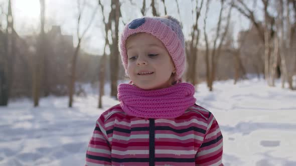 Smiling Child Kid Girl Tourist Walking Having Fun on Snowy Road in Winter Sunny Park Forest Sunset alt