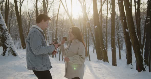 Happy Young Beautiful Couple Spend Time in Sunny Winter Forest Together alt
