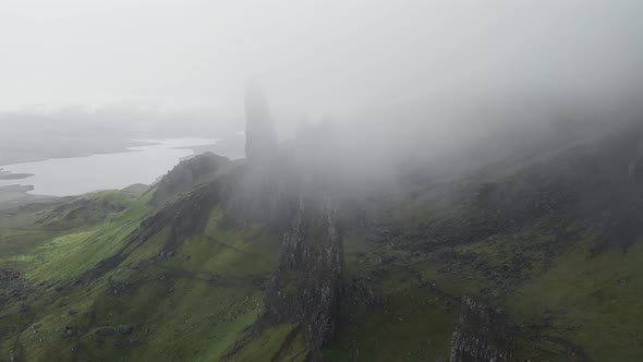 Parallax drone shot of old man of storr landscape in scotland during cloudy and foggy day. Scotland alt