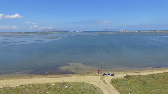 Aerial drone view of a man kiteboarding on a kite board. alt
