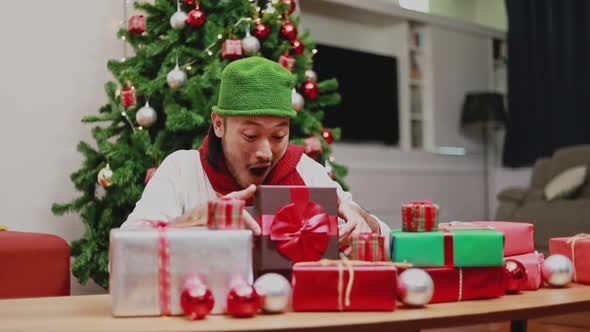 Surprise Asian men open the gift box in the living room.