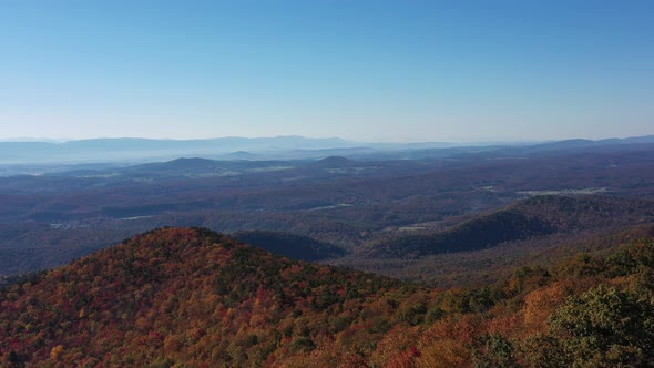 An aerial shot (dolly out) of Tibbet Knob and the Shenandoah Valley in Autumn. Red, Orange and Yello alt