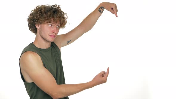 Caucasian Cheerful Guy with Curly Hair Looking on Camera Inviting with Facial Expressions to Look at alt