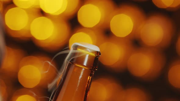 Man opens a bottle of beer with bottle opener on a bokeh background