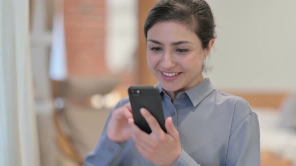 Portrait of Young Indian Woman Celebrating on Smartphone alt