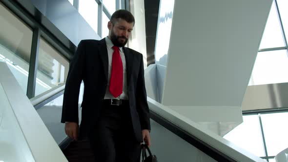 Cute Caucasian Man Chief Executive Officer Descends the Stairs in the Office of a Modern Company alt