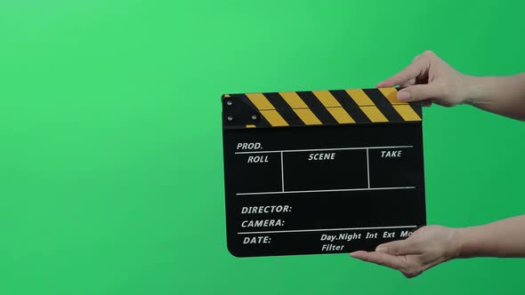 Film Slate or Movie Clapperboard with Blue Green screen background. Film crew man hold and hit