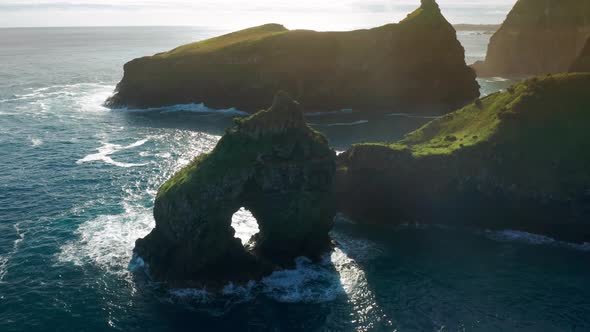 A Rock with an Arque Between Giant Cliffs and the Wild Atlantic alt