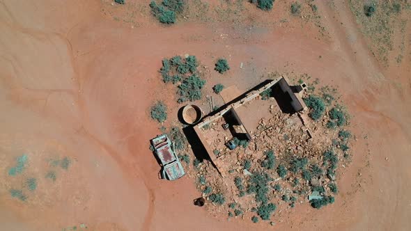 An old car left wrecked next to an abondoned building near Silverton alt