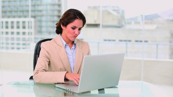 Concentrated Attractive Businesswoman Using Laptop