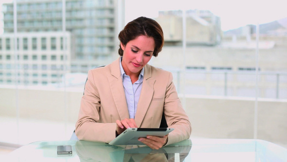 Dynamic Attractive Businesswoman Using A Tablet Pc
