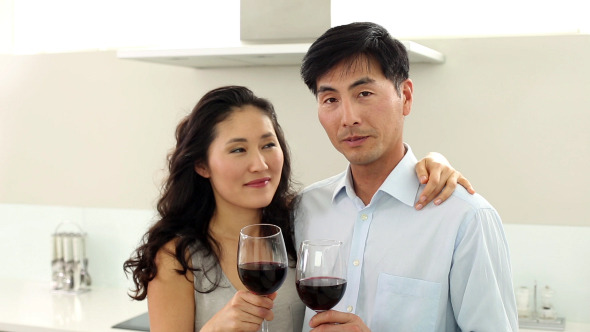 Couple Drinking Red Wine And Smiling At Camera