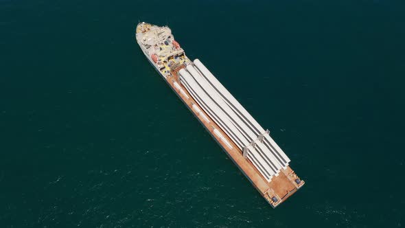 Heavy load carrier ship loaded with Electric Turbine Blades anchored at Sea. alt