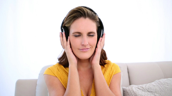 Smiling Woman Listening To Music On The Couch
