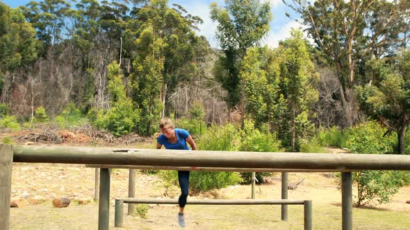 Fit man and woman climb a hurdles during obstacle course alt