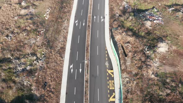 New empty four-lane road through desolate rural countryside, with clear surface marking of lanes alt