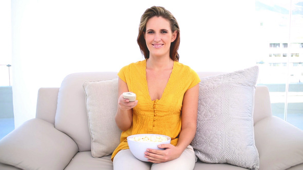 Smiling Woman Watching Tv With Popcorn