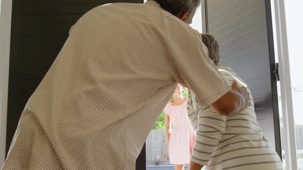 Rear view of senior black couple welcoming children at door in a comfortable home 4k alt