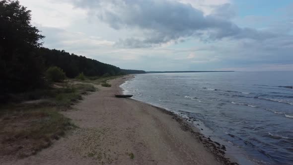Aeral view of beach and sea with rain clouds. Coastline perspective with rolling waves. alt
