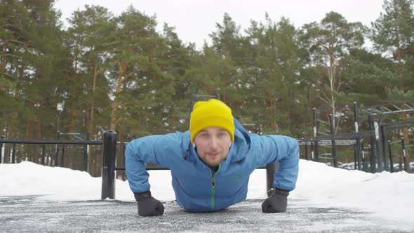 Cheerful Man Doing Push-Ups on Knuckles Outdoors in Winter alt