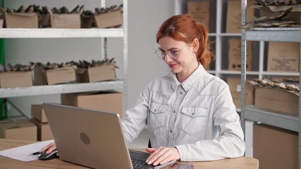 Fish Warehouse Young Female Entrepreneur Taking Orders From Customers in an Internet Store Small alt