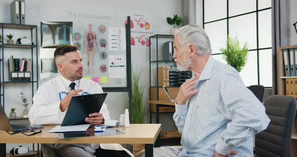 Man which Telling About His Health Complaints with Good-Looking Caring Experienced Bearded doctor alt