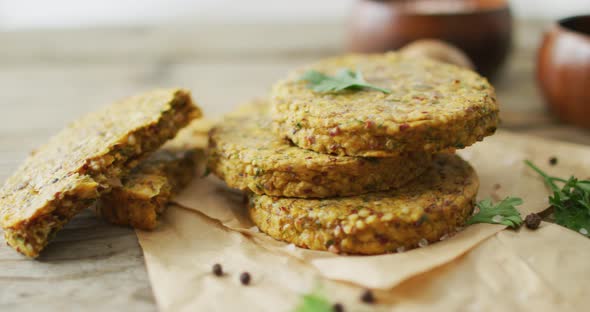 Video of fresh leaves and vegetarian burgers with bowls over wooden background alt