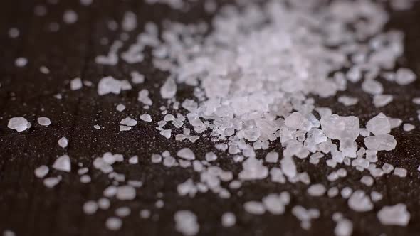 Crystals of White Sea Salt Fall on the Wooden Table alt