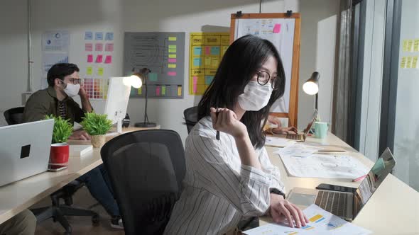Asian creative business team working at office after lockdown with protective prevention face mask.