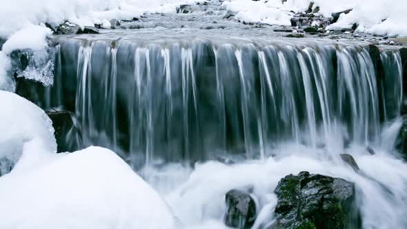 Wonderful Frozen Foot of a Waterfall with a Powerful Stream of Water at Winter Carpathian Mountains
