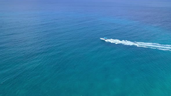 Aerial Drone Shot Over Speed Boat with small waves in Ocean.