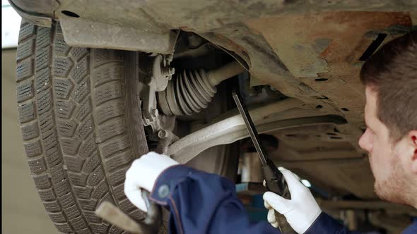 Auto Mechanic Checks the Suspension of the Car