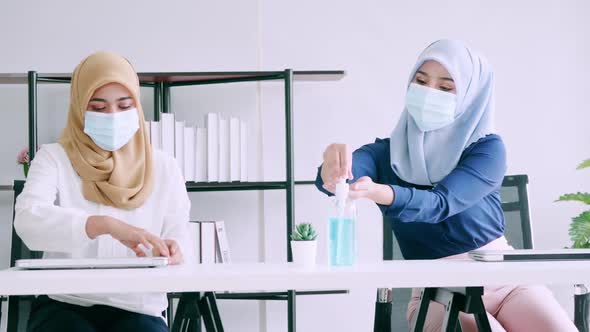 Muslim businesswomen wear protective masks and clean hands with sanitizer alcohol alt
