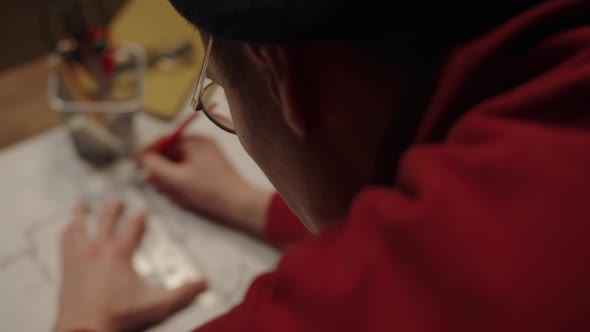 Young Designer is Standing Near Desk and Drawing Plan with Ruler and Compass Making Notes in Project alt