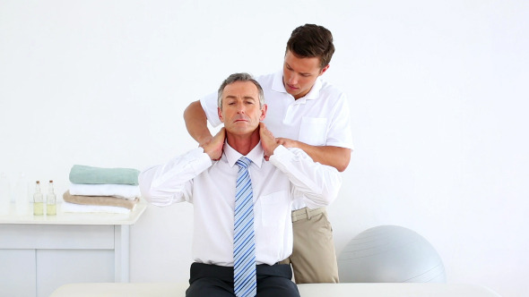Stressed Businessman Getting His Shoulders Checked