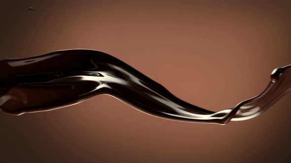 Super Slow Motion Shot of Waving Chocolate Splash on Brown Gradient Background at 1000 Fps alt