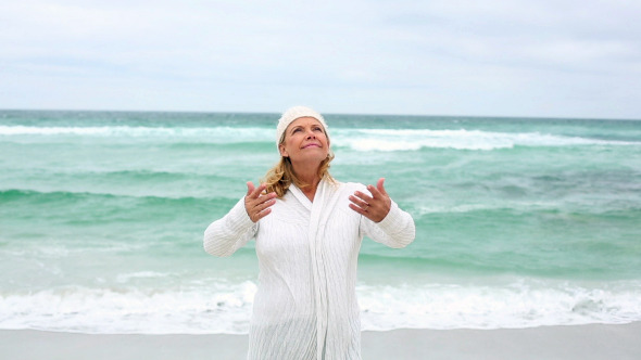 Retired Woman Spreading Her Arms By The Sea