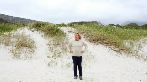 Happy Retired Woman Standing On The Beach