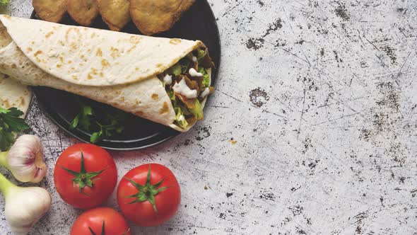 Traditional Turkish Doner Kebab in a Wrap Served with Fresh Ingredients and Deep Fried Dumplings alt