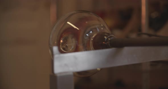 Professional glassblower working with glass at the workshop alt