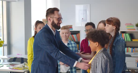 Teacher Giving Medal to African Boy for Best School Project alt