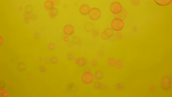 Soap Bubbles Lit By Red Neon Lights are Flying on a Yellow Background alt