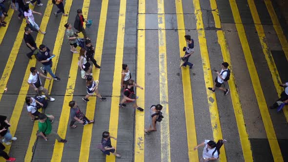 Aerial top view of crowd of people walking crossing on the street in Hong Kong. alt