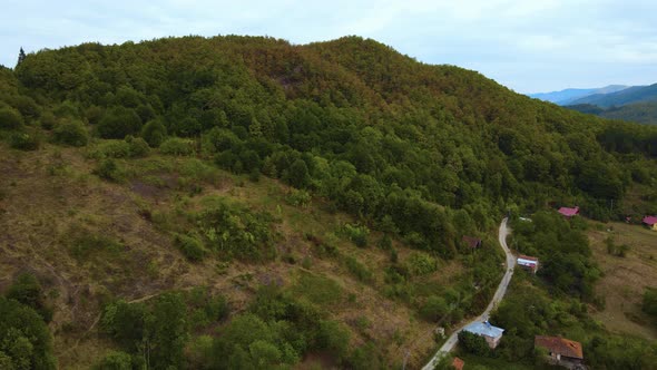 steep green mountains, deep forest and mountain road, beautiful valley and village houses alt