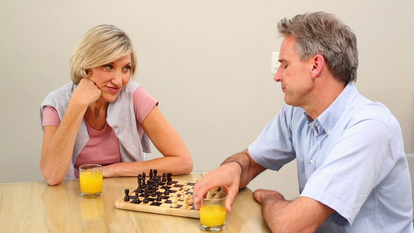 Mature Couple Playing Chess At The Table