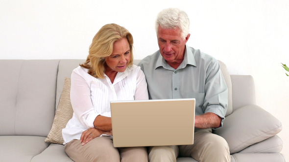 Retired Happy Couple Using Their Laptop
