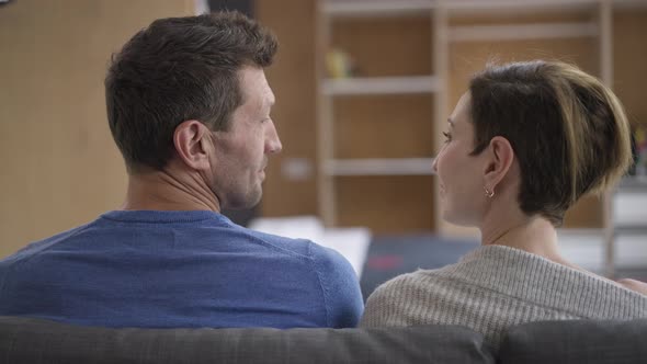 Happy Loving Man and Woman Sitting on Couch Looking at Each Other Putting Heads Together alt