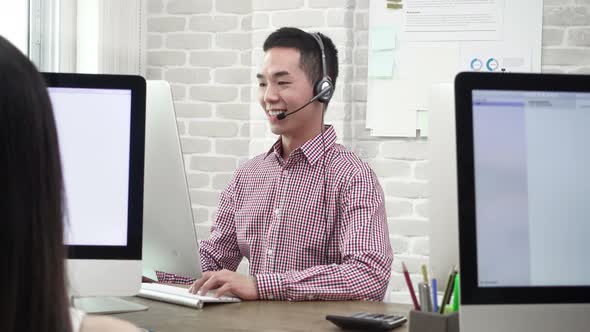 Asian man telemarketing customer service agent working in call center office