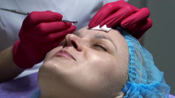 Close-up of beautician doing face cleaning treatment using mechanical instrument. alt