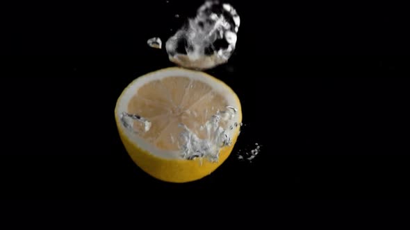 Lemon Falling into Water Super Slowmotion, Black Background, lots of Air Bubbles, 4k240fps alt
